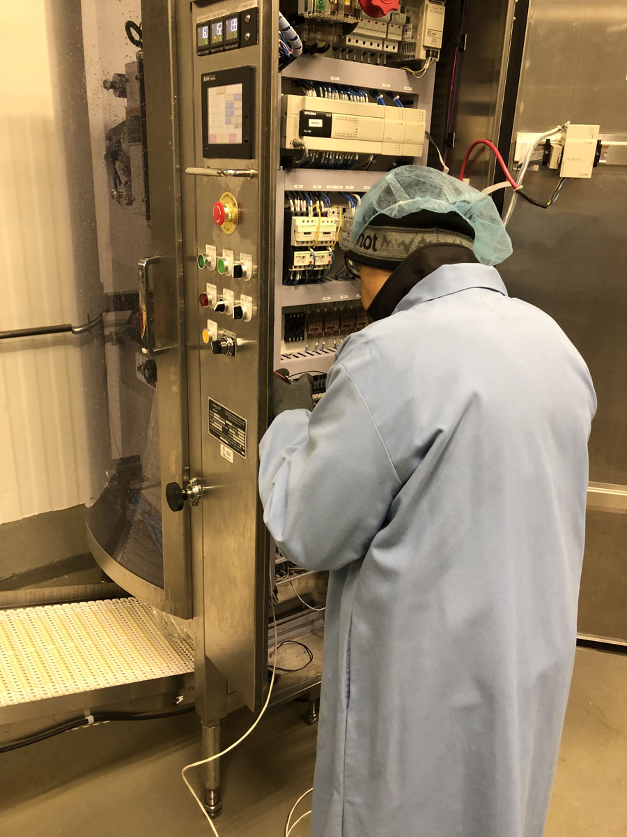 Technician performing electrical maintenance on industrial control systems